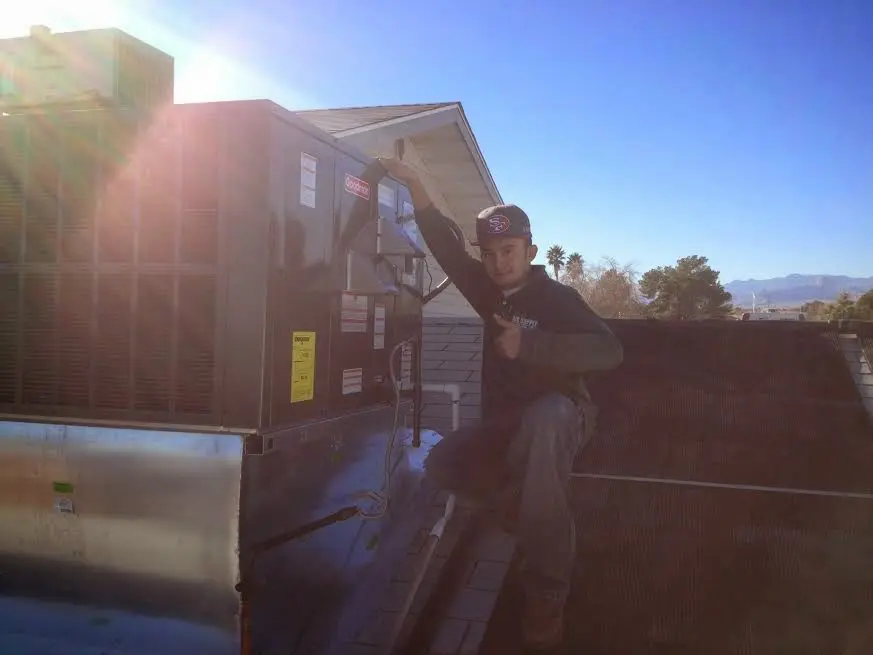 HVAC technician performing AC Tune-Up on a rooftop unit in Enid